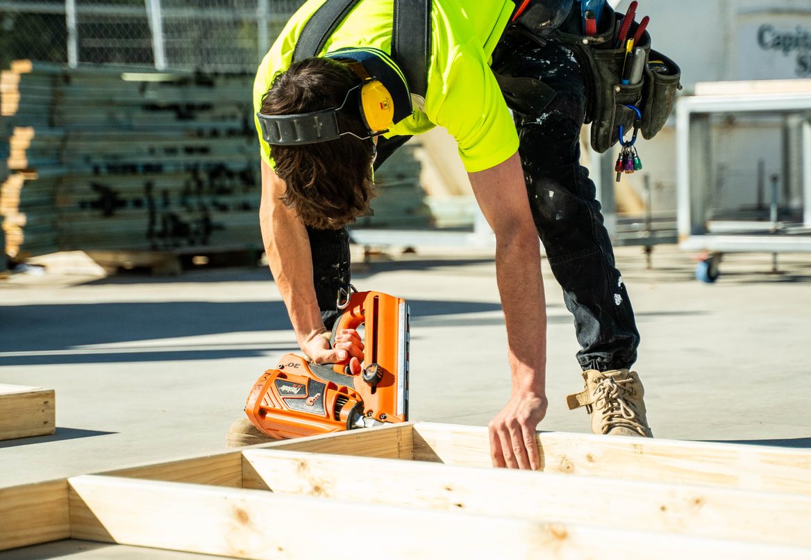 Carpenter using a circular saw on a timber frame